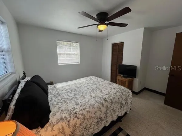 a bed sitting in a bedroom next to a window