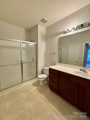 a bathroom with a double vanity sink toilet and mirror