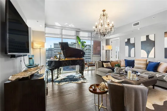 a living room with furniture a flat screen tv and kitchen view