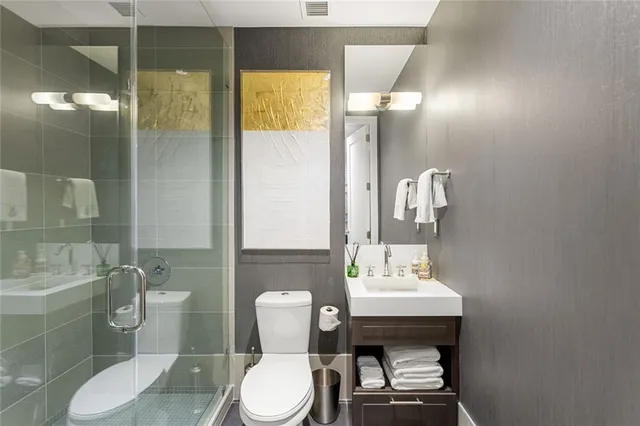 a bathroom with a sink a toilet a mirror and shower