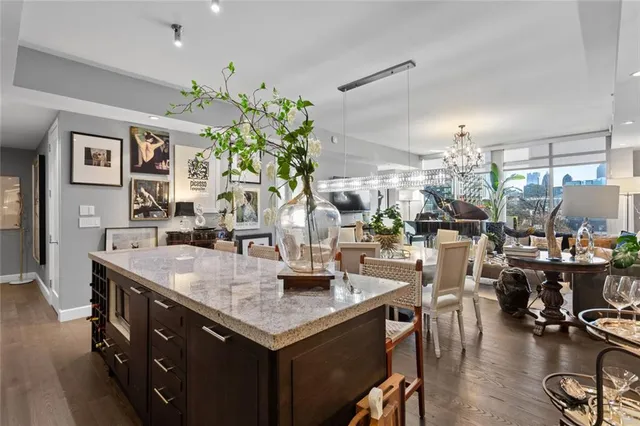 a dining hall with stainless steel appliances kitchen island granite countertop a table and chairs in it