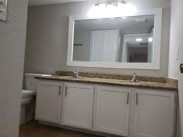 a bathroom with a granite countertop sink and a mirror