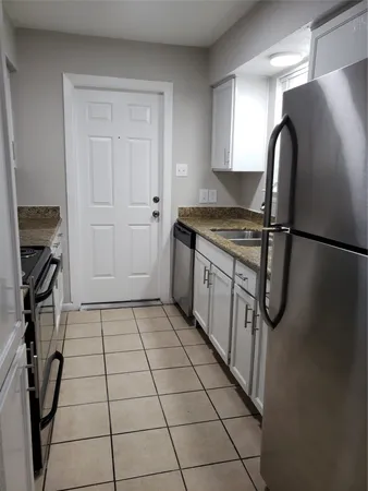 a kitchen with a stove a refrigerator and cabinets