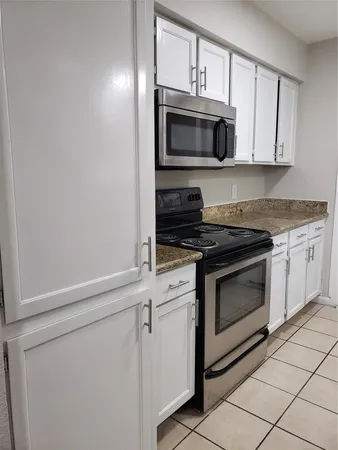 a kitchen with white cabinets stainless steel appliances and sink