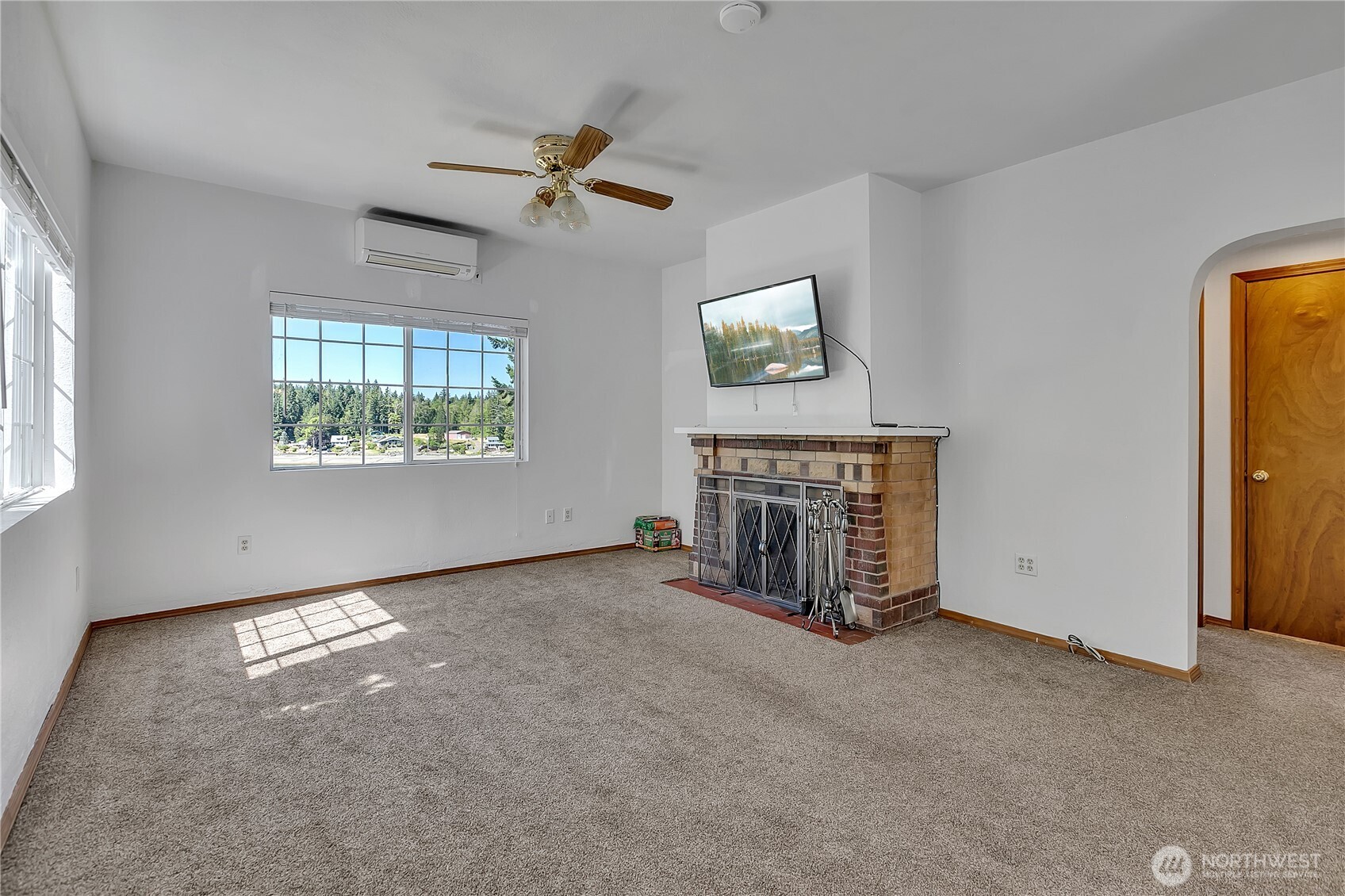 3253 Southeast Arcadia Road Shelton, WA 98584 - Photo 8 of 39 an empty room with windows chandelier and fireplace