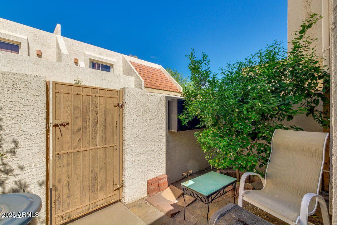 1342 West Emerald Avenue, Unit 329 Mesa, AZ 85202 - Photo 4 of 12 a balcony with a potted plant and outdoor seating