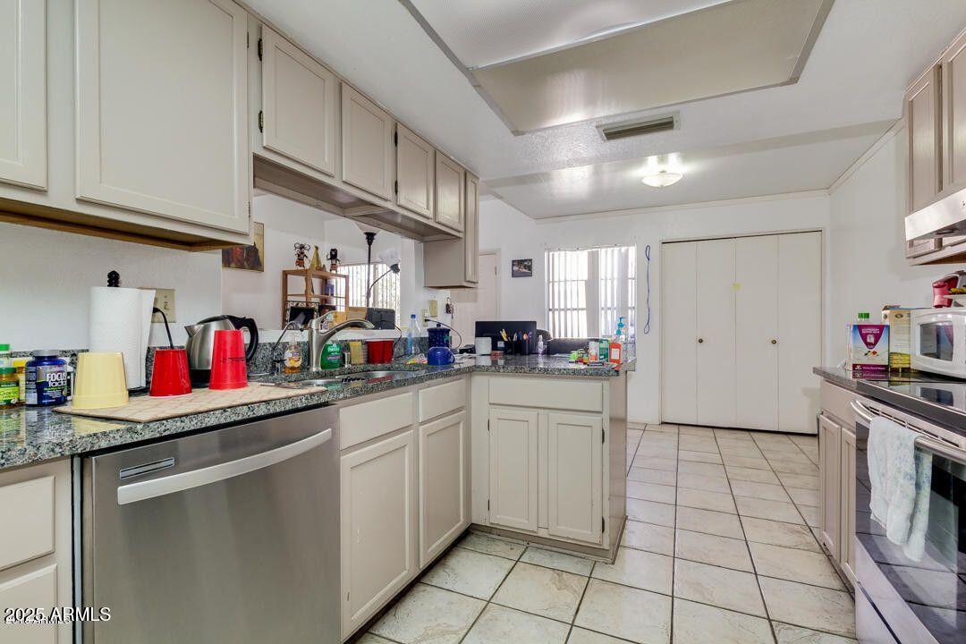 1342 West Emerald Avenue, Unit 329 Mesa, AZ 85202 - Photo 8 of 12 a kitchen with stainless steel appliances granite countertop a sink and cabinets