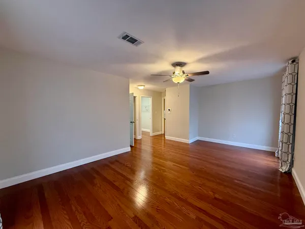 a view of an empty room with wooden floor