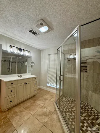 a spacious bathroom with a granite countertop sink mirror and shower