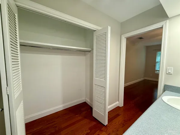 a view of a hallway with wooden floor and closet