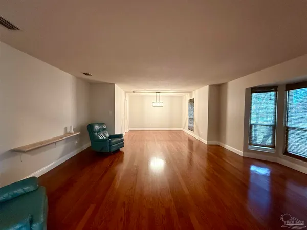 a big room with wooden floor and windows