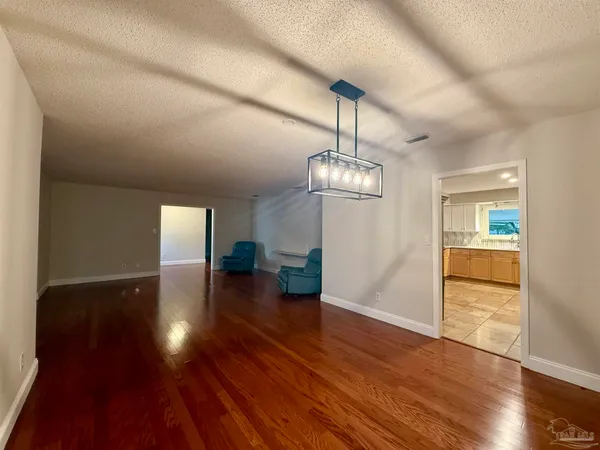 a view of a room with wooden floor staircase and a kitchen