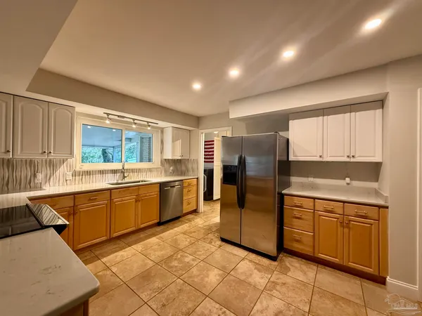 a kitchen with stainless steel appliances granite countertop a refrigerator and a sink