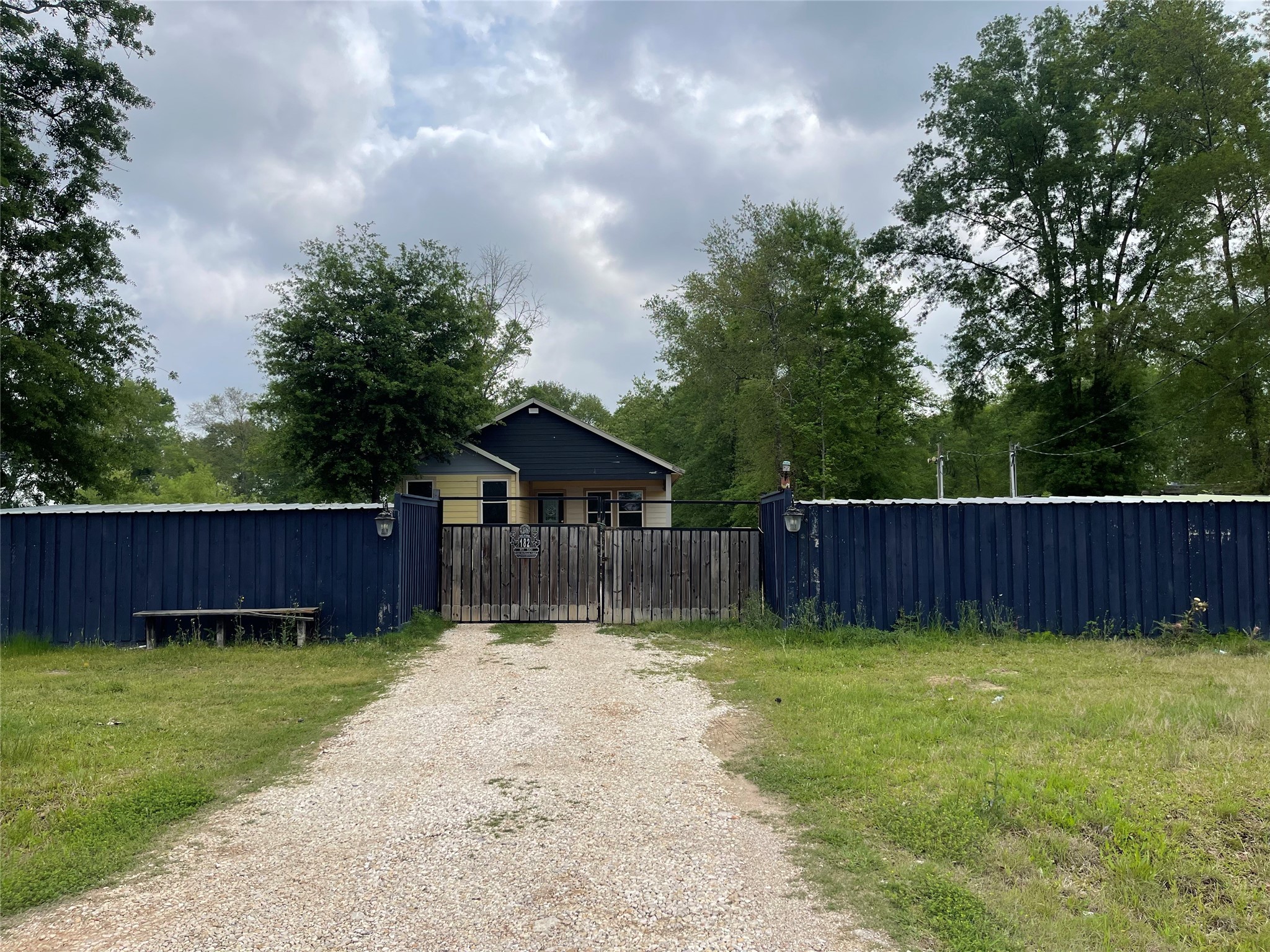 a view of backyard with wooden fence and trees