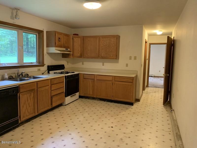 12 Quiet Knoll Road Stockbridge, MA 01266 - Photo 11 of 37 a kitchen with stainless steel appliances a sink a stove a refrigerator cabinets and a window