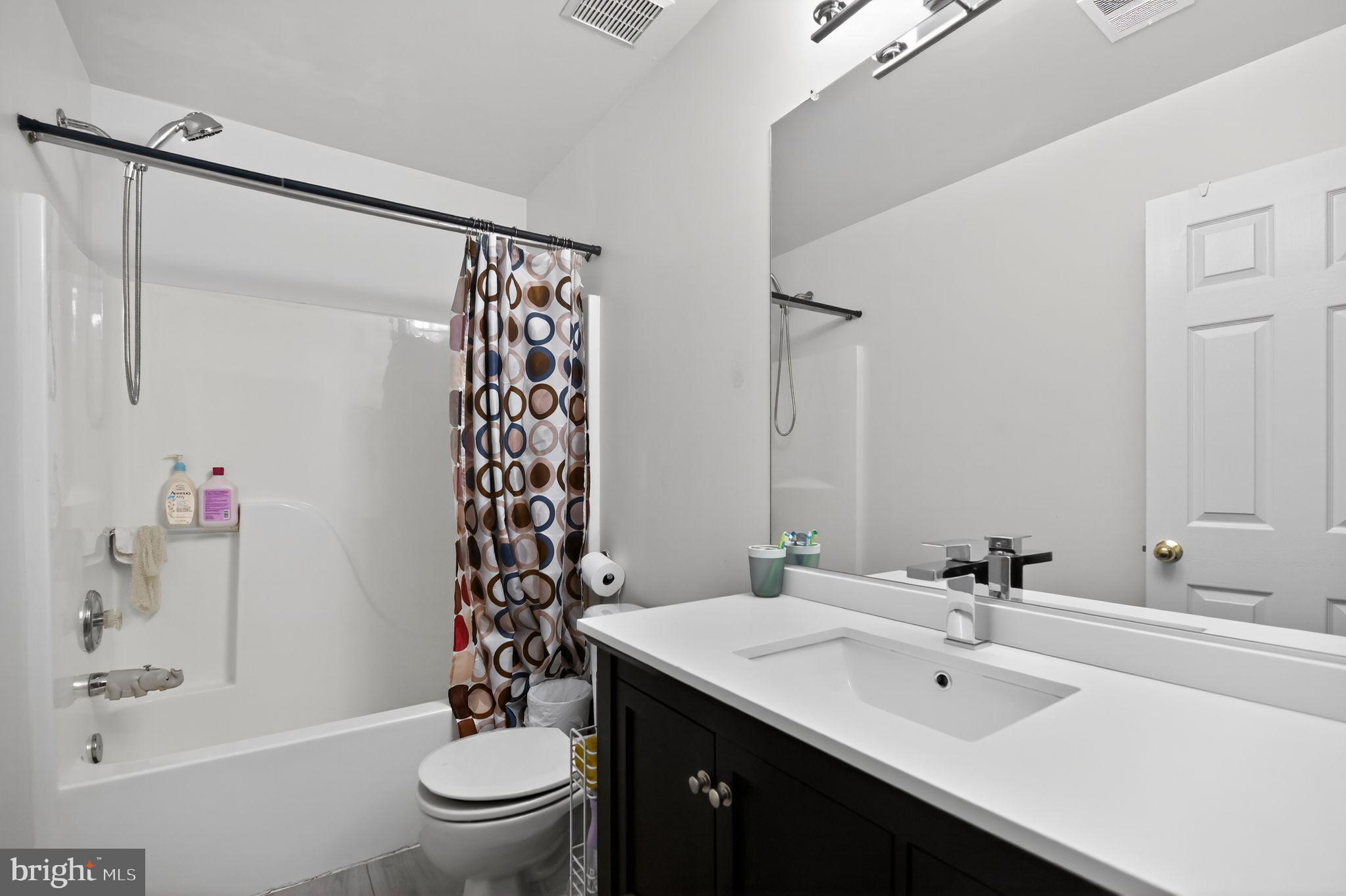 17326 Sligo Loop Dumfries, VA 22026 - Photo 12 of 34 a bathroom with a sink a toilet and shower curtain