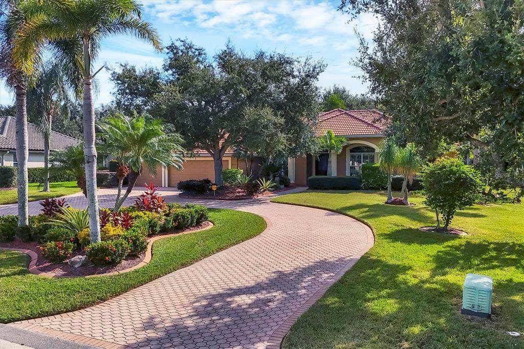a front view of a house with swimming pool and garden