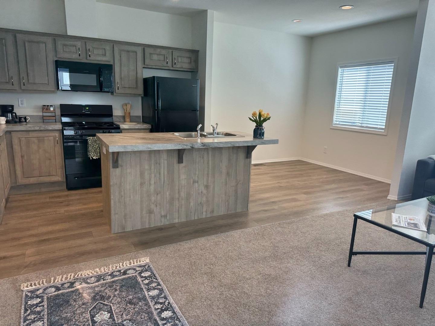 5812 Cedars Road, Unit 3 Redding, CA 96001 - Photo 3 of 14 a kitchen with kitchen island stainless steel appliances a stove refrigerator sink and microwave