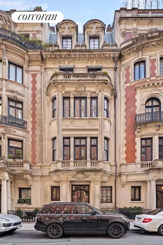 a front view of a building with cars parked