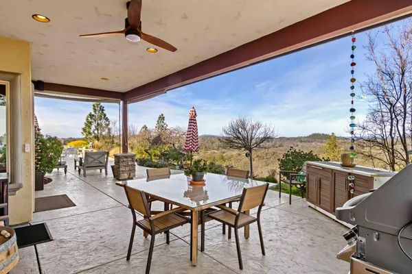 a kitchen with stainless steel appliances kitchen island granite countertop a table and chairs in it
