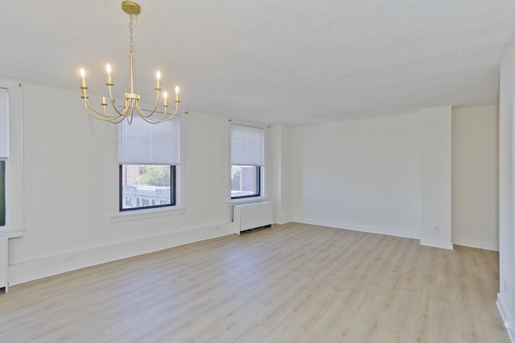 140 Chestnut Street, Unit 404 Springfield, MA 01103 - Photo 5 of 15 a view of an empty room with chandelier and wooden floor