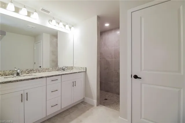 a bathroom with a granite countertop sink a mirror and a shower