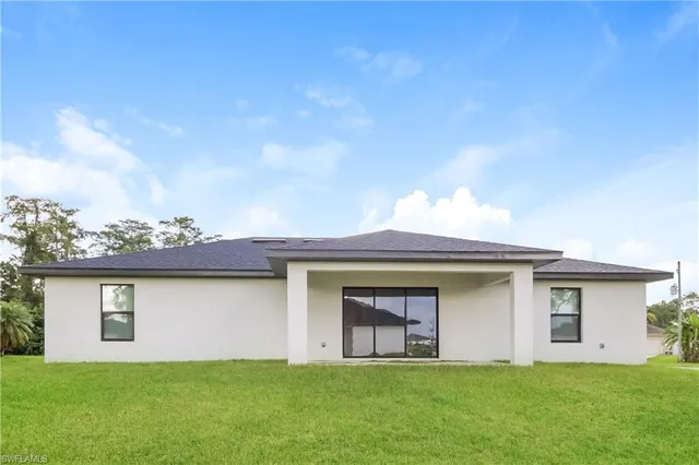 a view of a yard in front of a house with a large tree