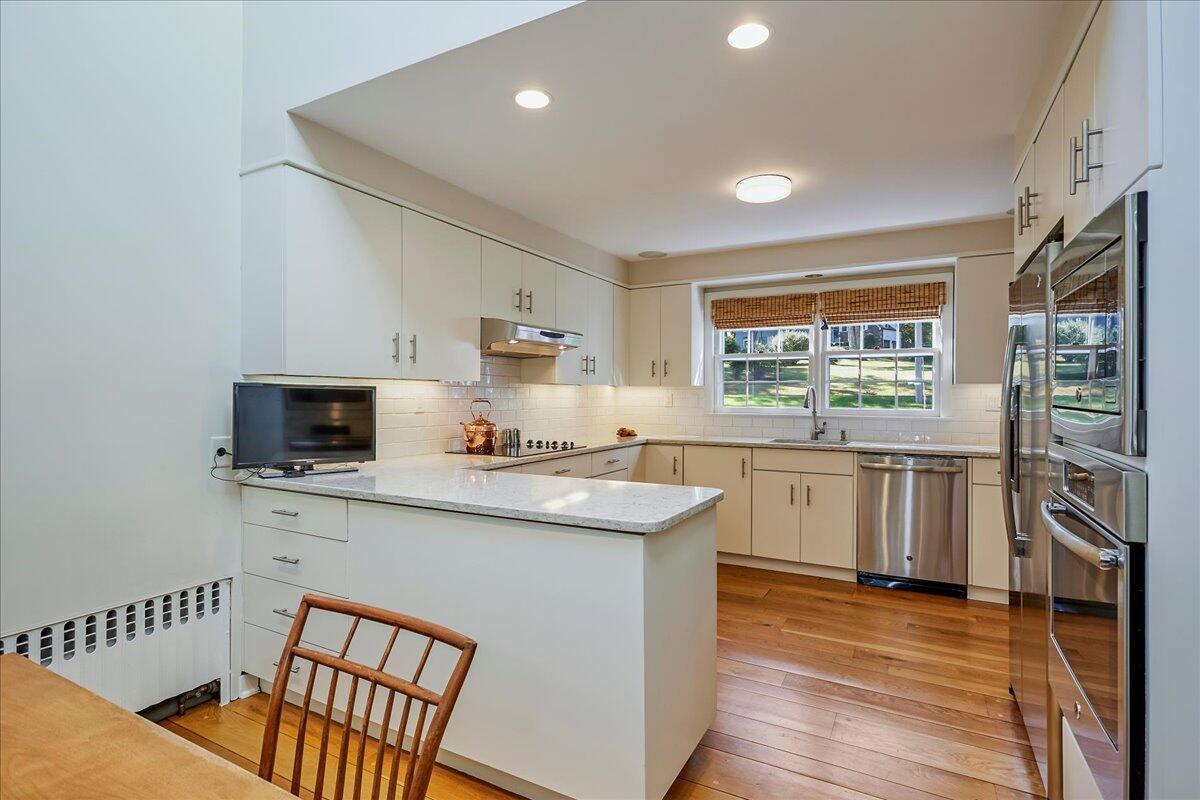 110 Ridge Acres Road Darien, CT 06820 - Photo 12 of 30 a kitchen with stainless steel appliances a stove top oven a sink dishwasher and a refrigerator with wooden floor