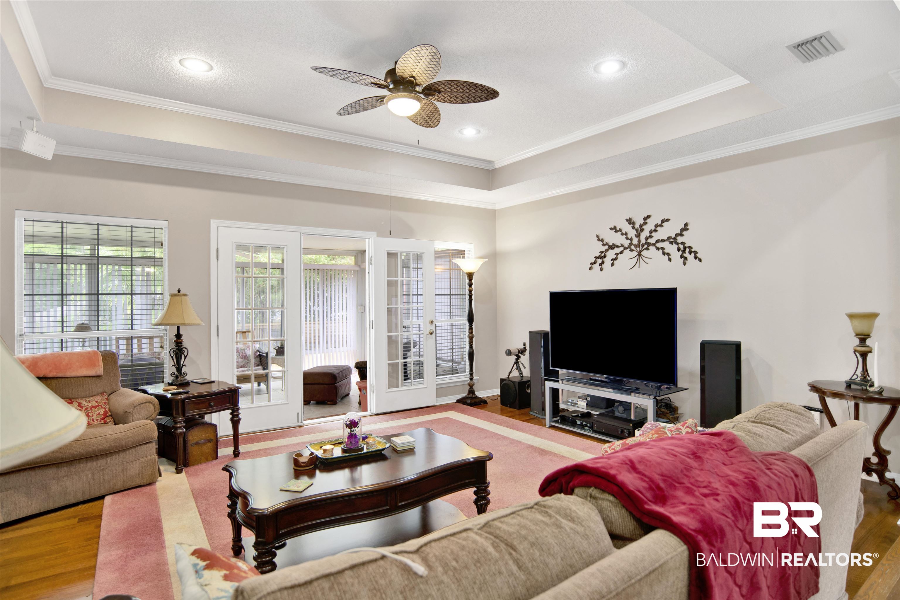 107 Virginia Circle Daphne, AL 36526 - Photo 8 of 47 Living area with tray ceiling, recessed lighting, wood-finish flooring, and double French doors opening to an enclosed porch