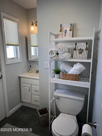 a bathroom with a toilet a sink and a window
