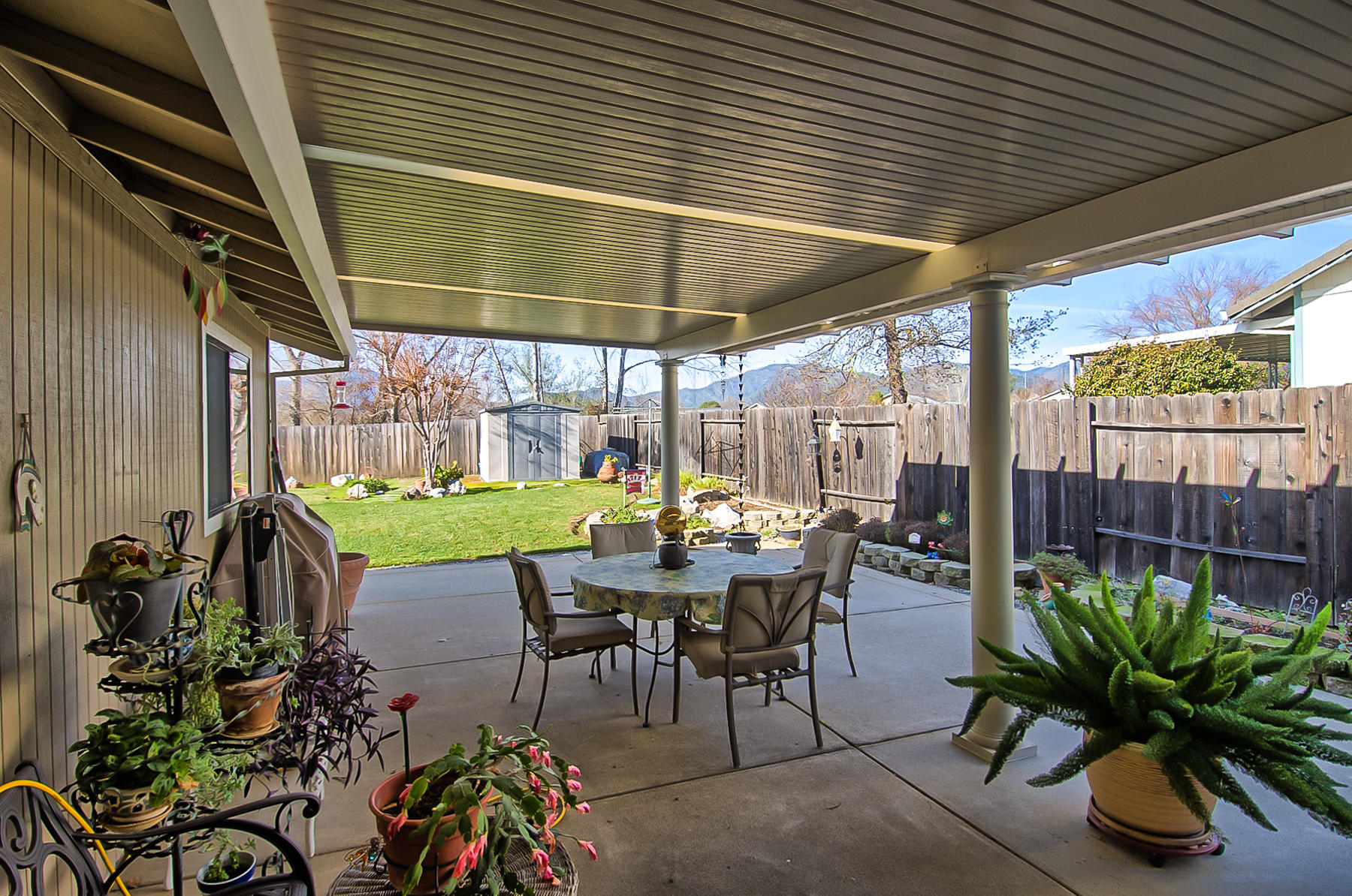 11326 Puffin Way Redding, CA 96003 - Photo 20 of 26 a view of a patio with table and chairs potted plants and floor to ceiling window