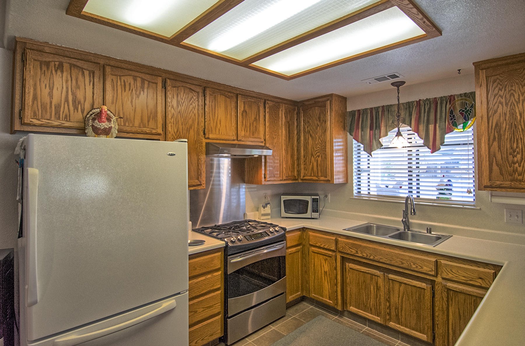 11326 Puffin Way Redding, CA 96003 - Photo 7 of 26 a kitchen with stainless steel appliances a refrigerator sink and cabinets