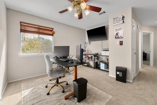 a view of a livingroom with workspace and a window
