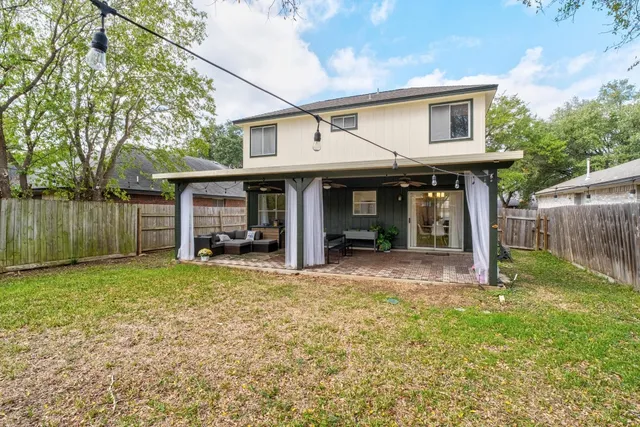 a view of a house with a yard and wooden fence