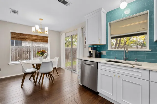a kitchen with a table chairs sink and cabinets