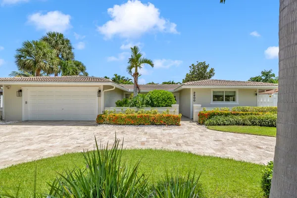 a view of a house with backyard and a tree