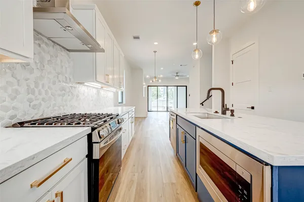 a kitchen with a sink stove and wooden floor