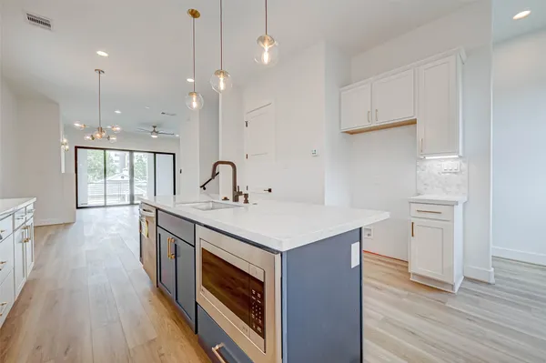 a kitchen with a sink stove and wooden floor