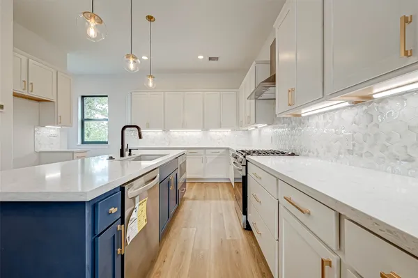 a kitchen with kitchen island a sink appliances and cabinets