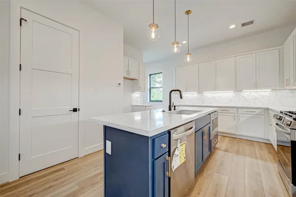 a kitchen with a sink stove and cabinets