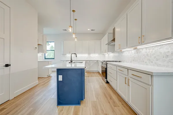 a large kitchen with granite countertop a large counter top space a sink stainless steel appliances and cabinets