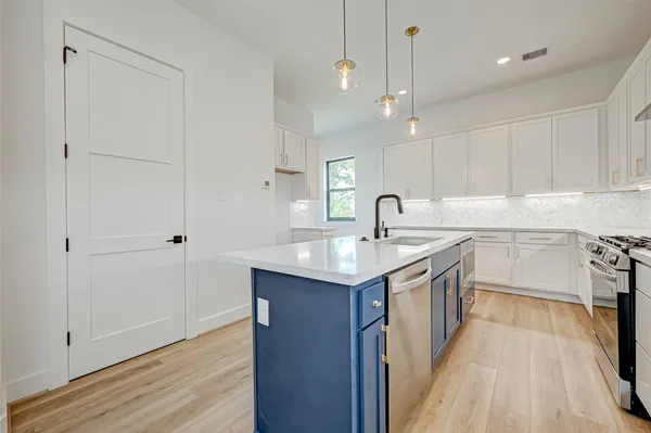 a kitchen with a sink stove and cabinets
