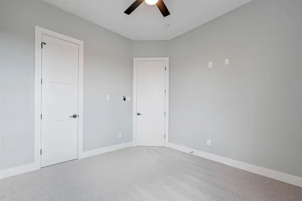 an empty room with chandelier fan