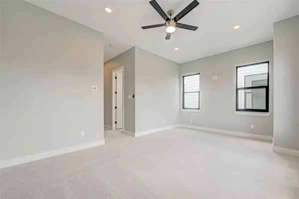 an empty room with windows and fan