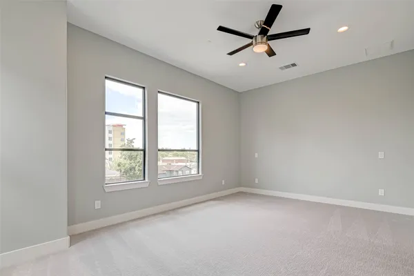 an empty room with a window and a fan