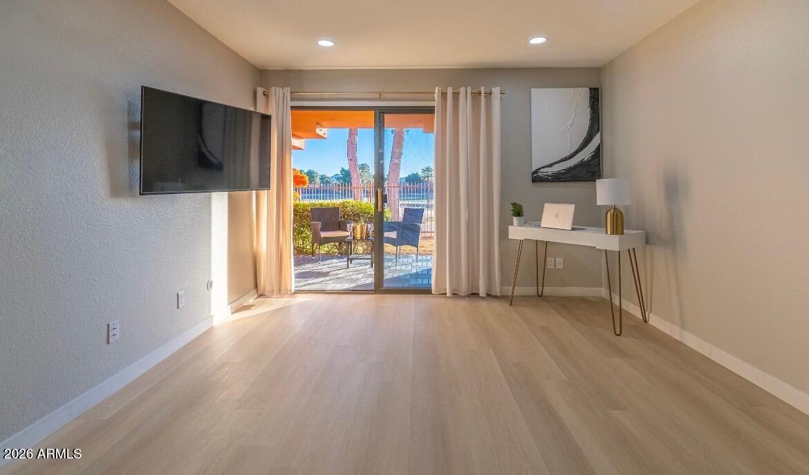 4303 East Cactus Road, Unit 128 Phoenix, AZ 85032 - Photo 5 of 39 an empty room with windows wooden floor and front door