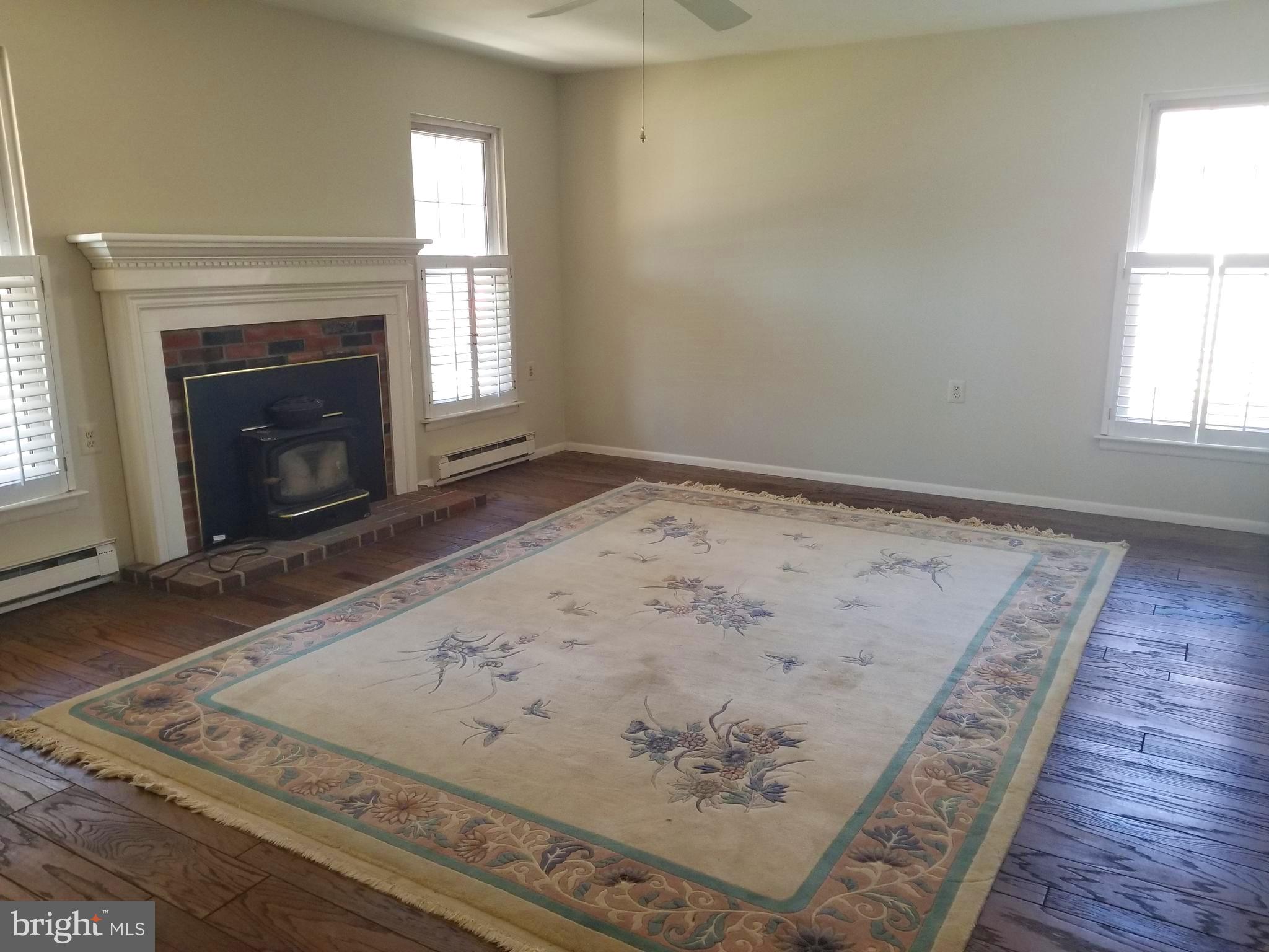 26 Dunstable Road Southampton, NJ 08088 - Photo 5 of 31 an empty room with wooden floor a fireplace and windows