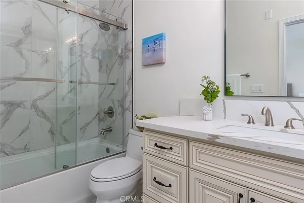 a bathroom with a granite countertop sink a toilet and a bathtub