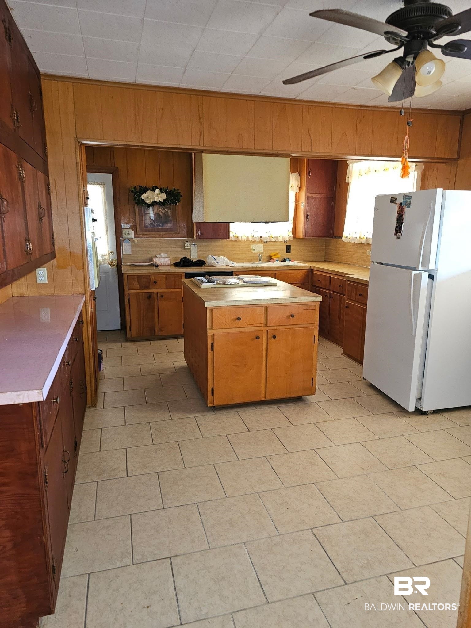 304 Sutherland Drive Mobile, AL 36611 - Photo 4 of 18 Kitchen with wood walls, tasteful backsplash, white refrigerator, a center island, and ceiling fan