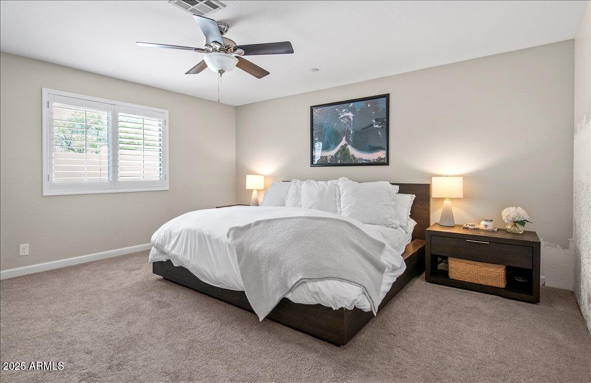 6520 East Osborn Road Scottsdale, AZ 85251 - Photo 10 of 21 a spacious bedroom with a bed and a chandelier